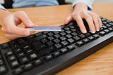 Woman typing on keyboard holding a credit card