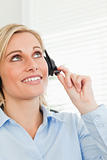 Smiling businesswoman with headset looking at the ceiling 
