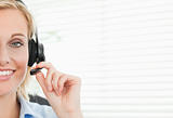 Close up of a smiling blonde businesswoman with headset looking 