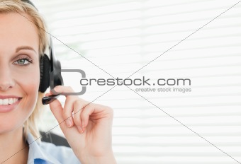 Close up of a smiling blonde businesswoman with headset looking 