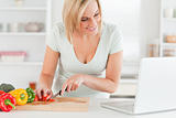 Woman enjoying cooking looking for a recipe on the laptop
