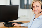 Close up of a blonde businesswoman with headset working with com