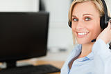 Portrait of a smiling blonde businesswoman with headset working 