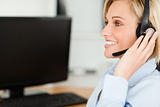 Portrait of a smiling blonde businesswoman with headset working 