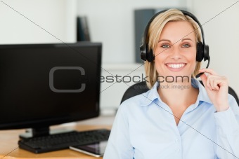 Close up of a blonde smiling woman wearing headset looking into 