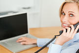 Young businesswoman smiling into camera while on the phone