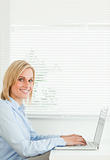Gorgeous smiling businesswoman working on laptop 