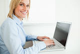 Close up of a gorgeous smiling businesswoman working on laptop 