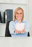 Gorgeous businesswoman holding a piggy bank 