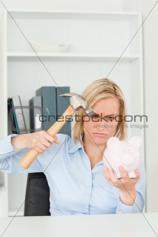 Angry woman wanting to destroy her piggy bank