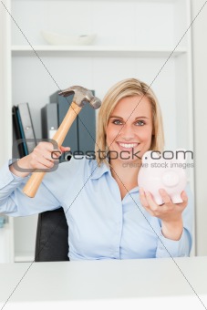 Happy woman wanting to destroy her piggy bank