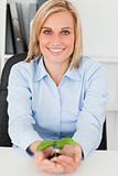 Businesswoman holding little green plant