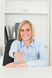 Smiling blonde businesswoman giving hand 