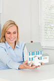 Smiling businesswoman showing model house