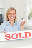 Gorgeous blonde businesswoman showing miniature house and SOLD 
