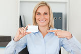 Businesswoman pointing at a card looks itno camera