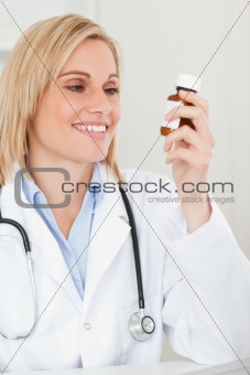 Smiling blonde doctor looking at medicine