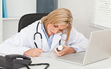 Doctor writing something down holding medicine