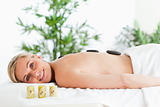 Blonde smiling woman having a stone therapy