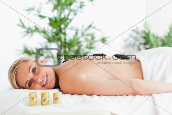 Blonde smiling woman having a stone therapy