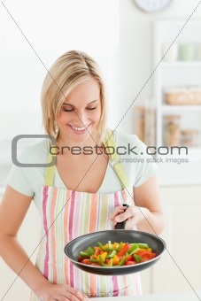 Cute woman looking at pan filled with peppers