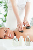 Blonde relaxed woman experiencing a stone therapy