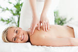 Blonde smiling woman relaxing on a lounger during massage