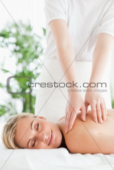 Gorgeous smiling woman relaxing on a lounger during massage 