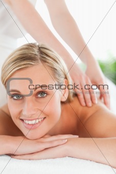 Close up of a smiling woman relaxing on a lounger during a massage