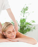 Close up of a blonde woman relaxing on a lounger enjoys a massage