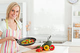 Woman showing cutted peppers in pan