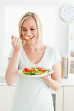 Portrait of a blonde woman enjoying mixed salad