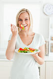 Portrait of a charming woman enjoying mixed salad
