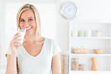 Woman drinking milk looks into camera