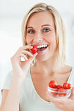 Portrait of a woman enjoying eating strawberries