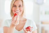 Close up of a woman enjoying eating strawberries 