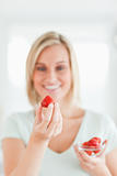 Woman looking at strawberry with pleasure