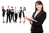 smiling businesswoman holding laptop and successful business team