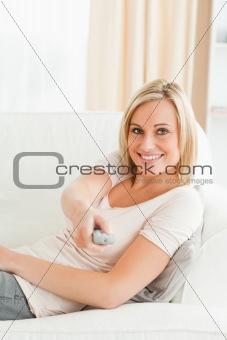 Portrait of a woman pointing a remote at the camera