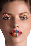 zoom on a girls face with rainbow lips and candy eye lids