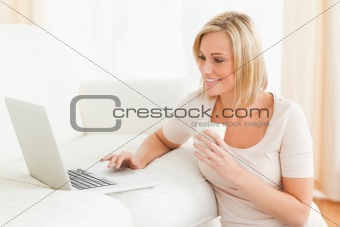 Woman holding a mug while using a laptop