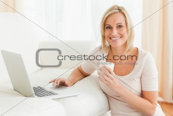 Woman holding a mug while with a notebook
