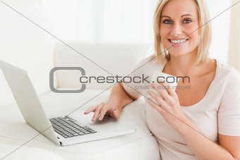 Close up of awoman holding a mug while with a notebook