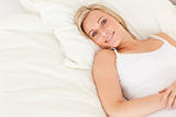 Blonde woman lying on her bed