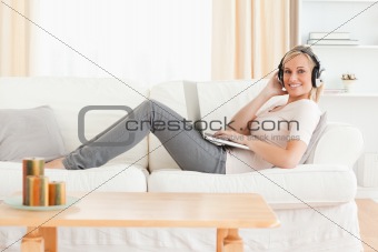 Blond-haired woman with a laptop and headphones