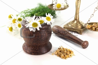 chamomile flowers with mortar and scales
