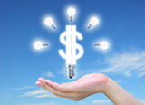 light bulb model of a dollar symbol in women hand on sky