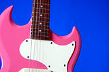 Pink Electric Guitar Isolated on Blue