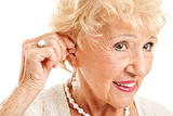 Senior Woman Inserts Hearing Aid