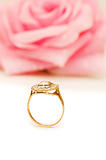 Golden ring and rose at the background